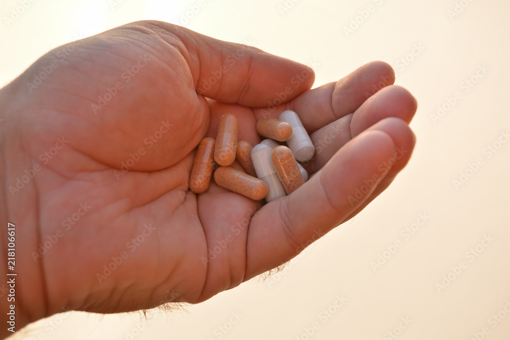 Mano mostrando un cóctel de diferentes medicamentos para el tratamiento de enfermedades como el VIH o simplemente como complementos alimenticios o adelgazamiento Mano mostrando un cóctel de diferentes medicamentos para el tratamiento de enfermedades como el VIH o simplemente como complementos alimenticios o adelgazamiento