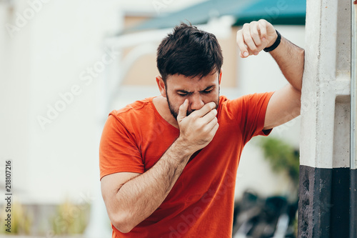 Portrait of young man drunk or sick vomiting outdoors photo