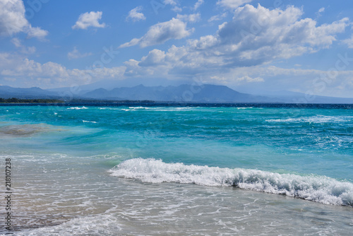 Fototapeta Naklejka Na Ścianę i Meble -  Azure beach with clear water and mountains on the background at sunny day. Tropical islands. Sea view amazing nature background. Paradise nature, sea water, summer on the tropical beach.