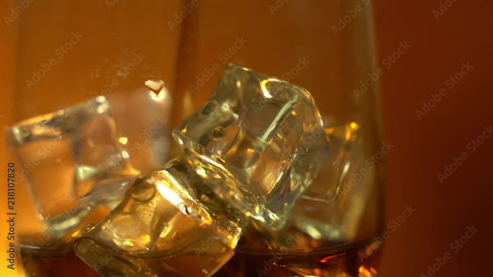Cola pouring into the glass with Ice cubes and bubbles. Food background. Soda Close-up. Cola pouring into the glass with Ice cubes and bubbles. Food background. Soda Close-up.