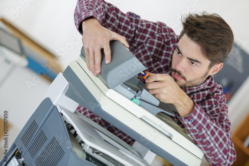 man mending the fax machine photo