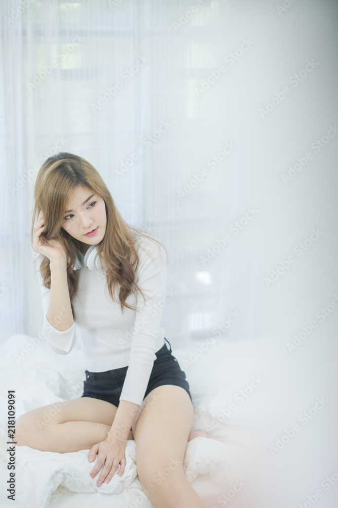 Naklejka premium Attractive Sexy Asian woman sitting in bedroom