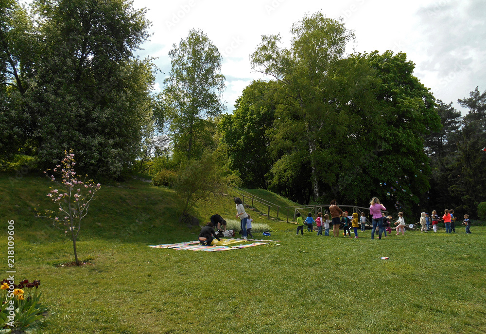 Children with educators play in nature in the botanical garden Children with educators play in nature in the botanical garden