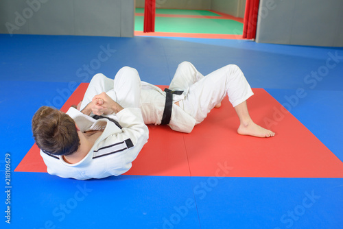 People in martial arts hold on floor