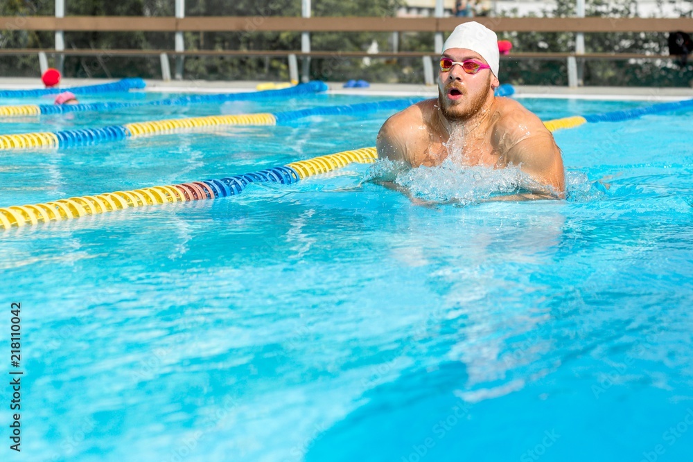 Male outdoor swims breaststroke in pool