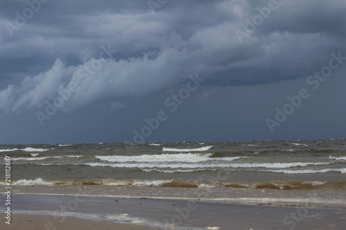 Baltic Sea. Summer. Dramatic storm clouds over the sea. Sea waves on the beach