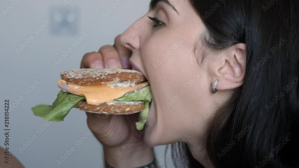 Young couple fun eat together bite a tasty sandwich simultaneously Young couple fun eat together bite a tasty sandwich simultaneously