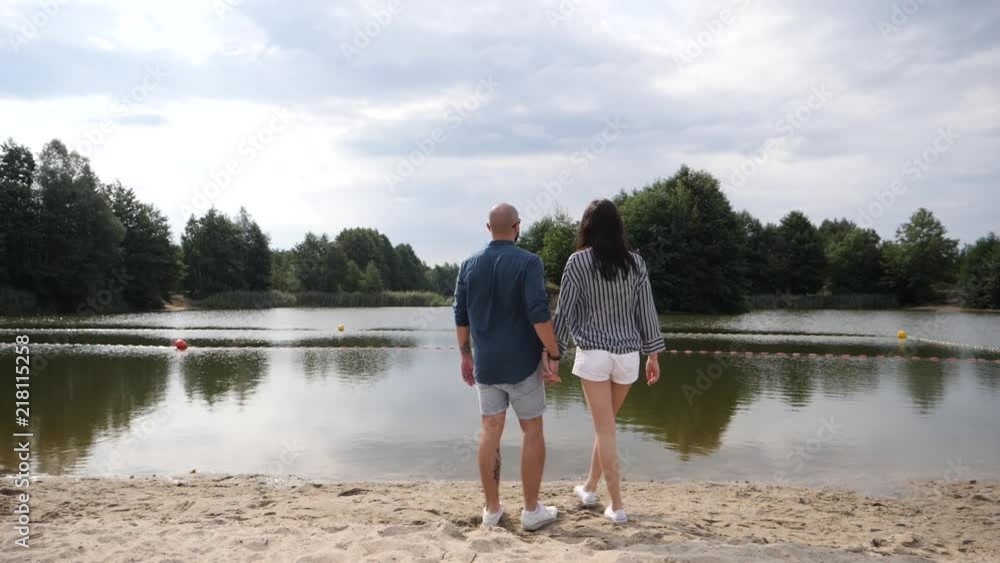 Young couple in love walking on nature holding hand in hand gently embracing Young couple in love walking on nature holding hand in hand gently embracing