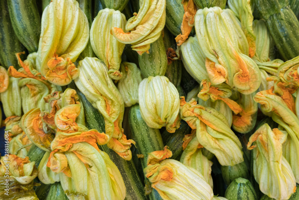 Fresh courgette flower stand at a street organic food market.