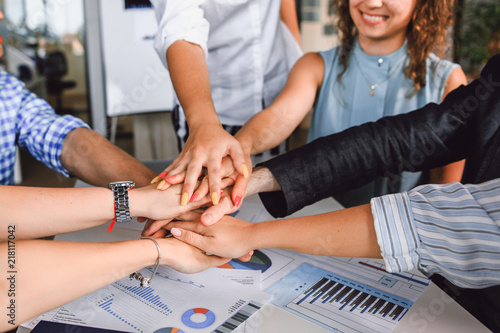 Obraz na plátně Entrepreneurs folded their hands together sitting at a table in the office close