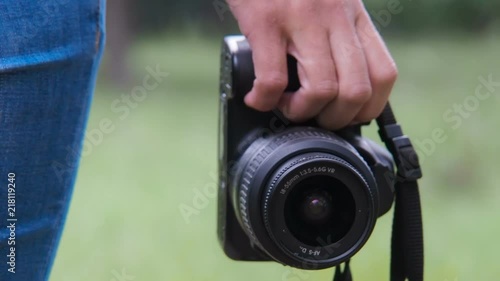 A girl in hands holds a camera. The camera is close-up. photo