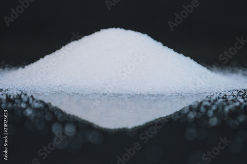Spilled white sugar on a black background.