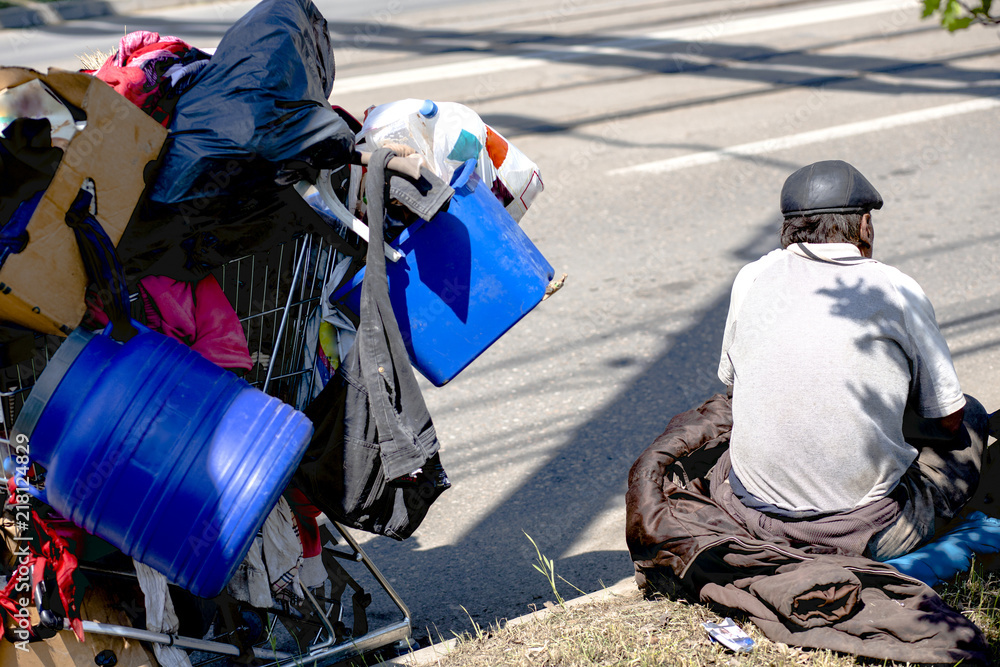 Poor old man or beggar begging you for help sitting at dirty slum with his stuff at sideroad. concept for poverty or hunger people,human Rights,donate and charity,background text, low economics Poor old man or beggar begging you for help sitting at dirty slum with his stuff at sideroad. concept for poverty or hunger people,human Rights,donate and charity,background text, low economics