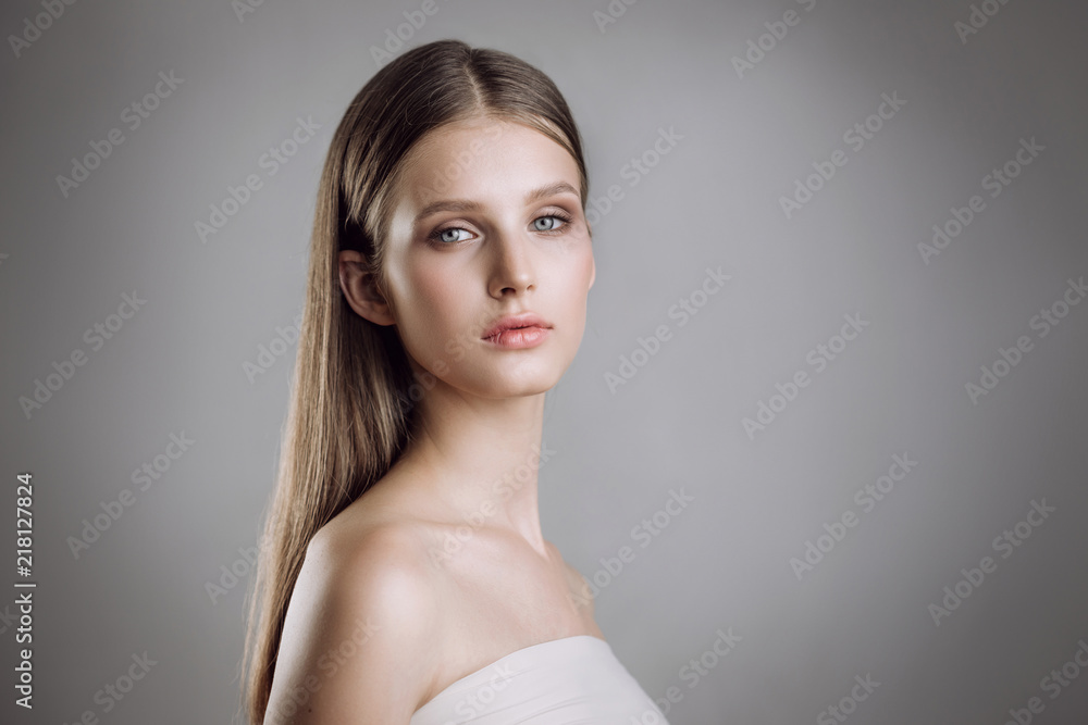 Portrait of a beautiful young girl with nude make-up in studio on a gray background Portrait of a beautiful young girl with nude make-up in studio on a gray background