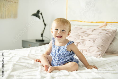 Cute baby girl on bed at home
