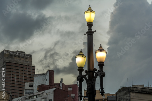 Old street lamp, symbol of the city of Sao Paulo, Brazil, in front of some metropolitan buildings.