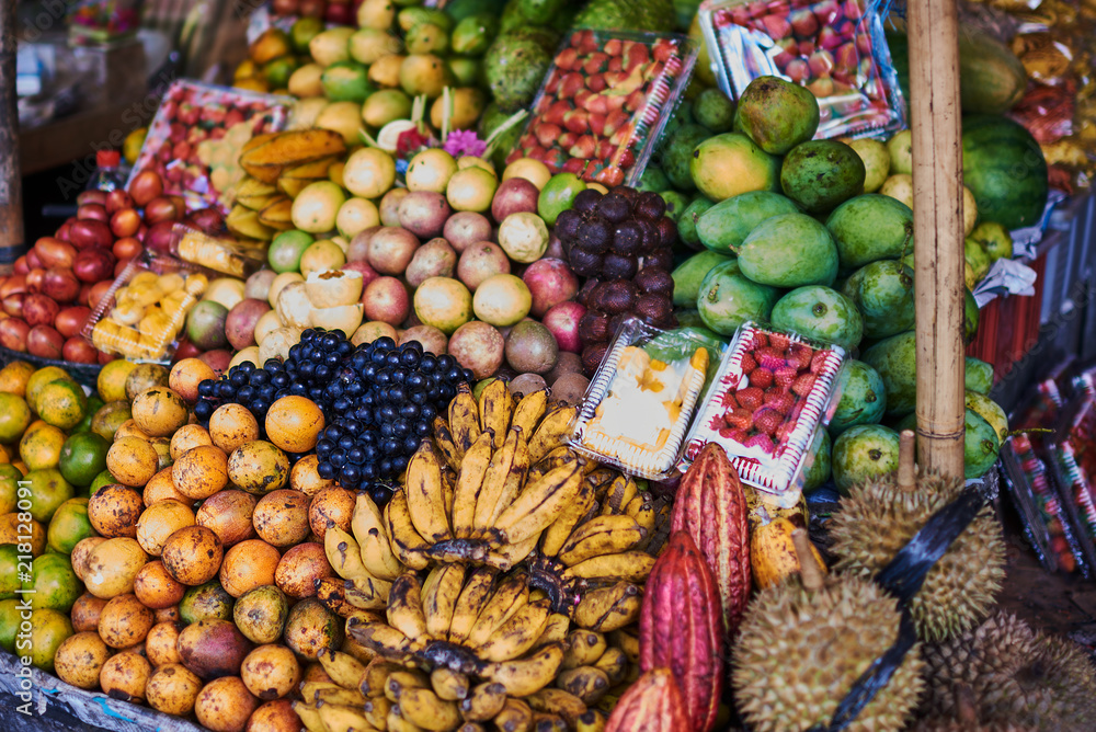 Asian exotic fruits. Market stall with variety of organic fruits. Colorful fruits in the marketplace. Bright summer background. Healthy, organic food. Natural nutrition for diet. Selective focus.