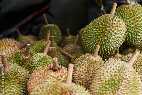 Fresh exotic tropical fruits Durian for sale at an outdoor market. Organic fruits on street market. Fruit season. Durian is king of fruit is famous Asian fruit. Food background. Selective focus.