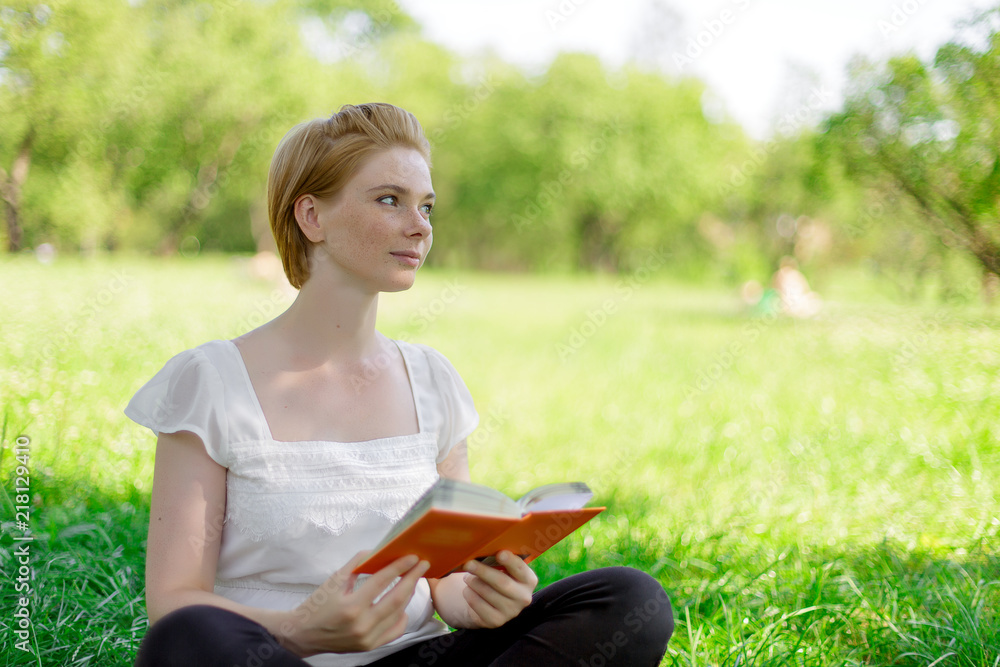 serious young, beautiful girl holding an open book, read background summer green park serious young, beautiful girl holding an open book, read background summer green park