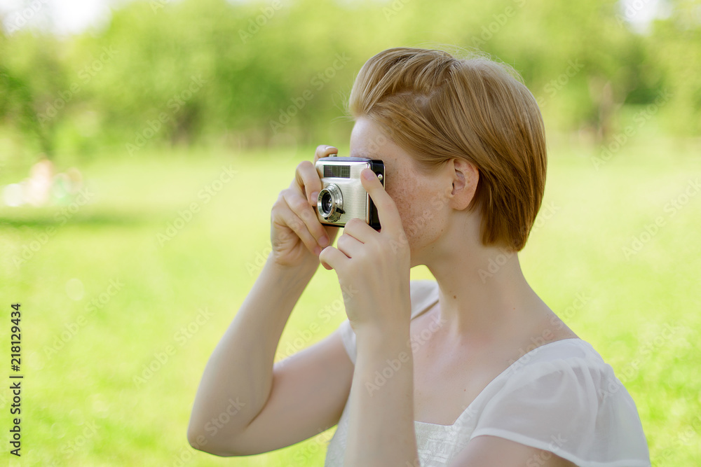 Portrait of beautiful young smiling woman with camera at summer green park Portrait of beautiful young smiling woman with camera at summer green park