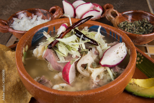 Pozole Close up con rabanos lechuga y condimentos
