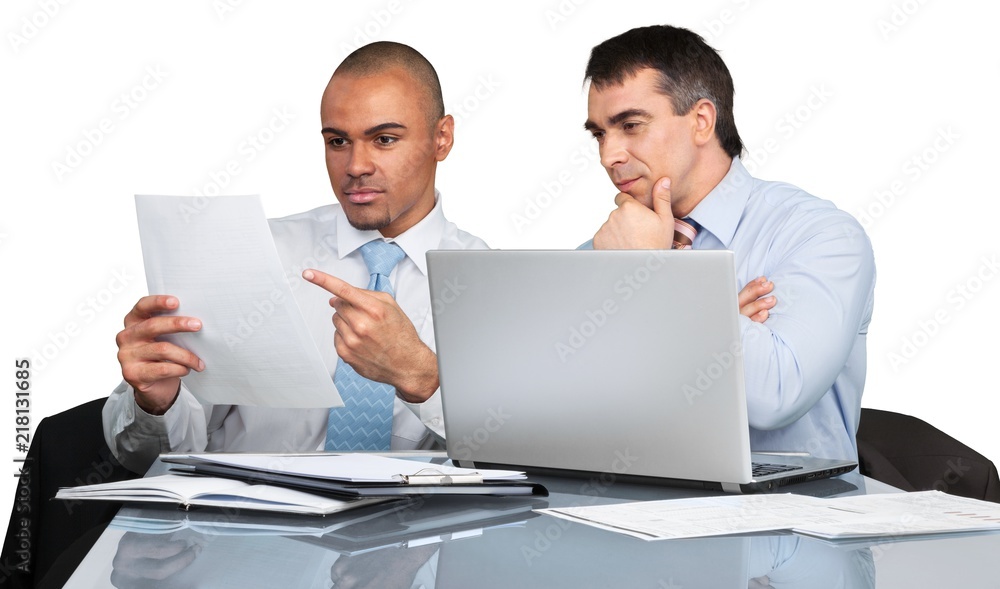 Business men using laptop while making report in office Business men using laptop while making report in office