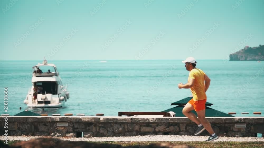 Slow motion shot of an athletic man running at seaside Slow motion shot of an athletic man running at seaside