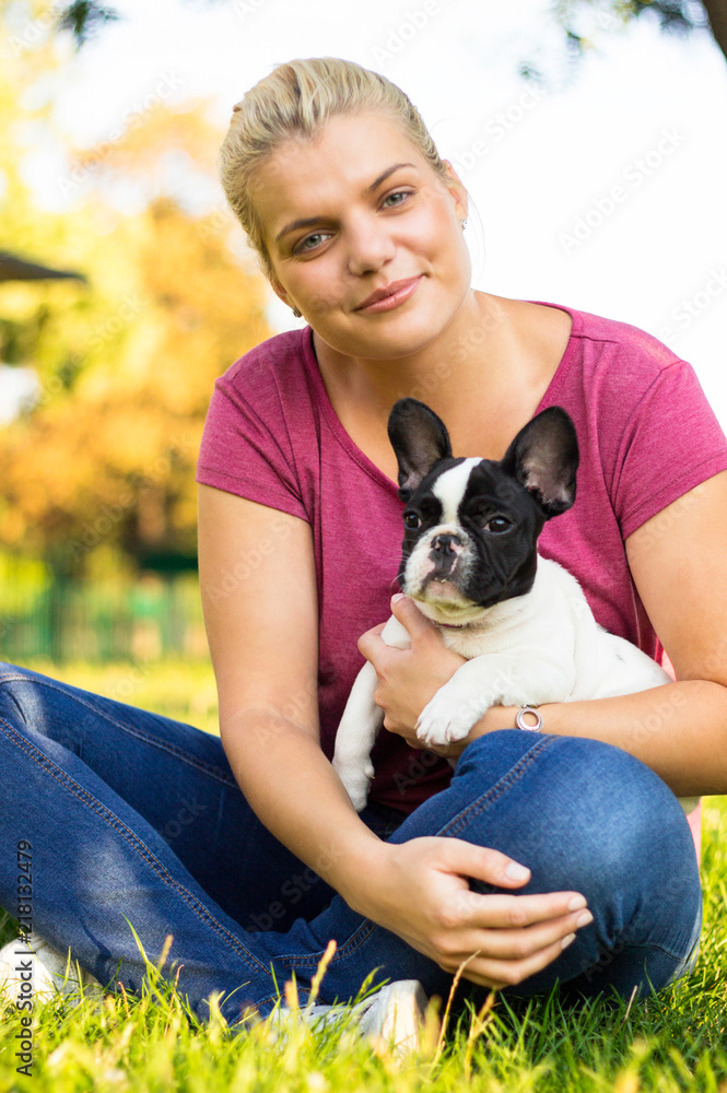 Smiling young woman playing with puppy. Her best friend Smiling young woman playing with puppy. Her best friend