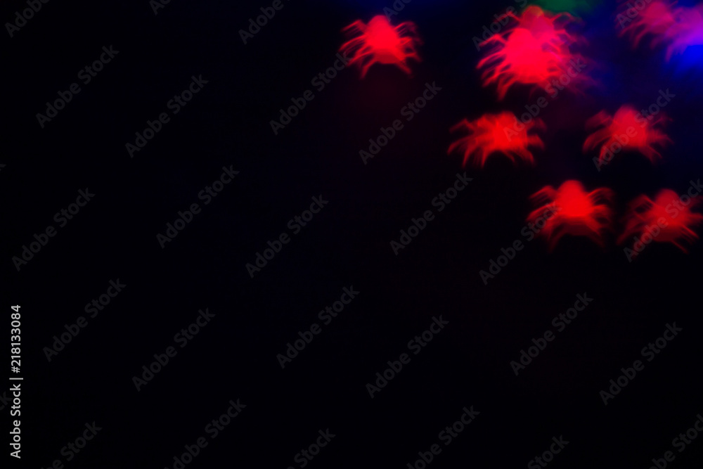 holidays, decoration and party concept - defocused bokeh red spiders silhouette on black for halloween background