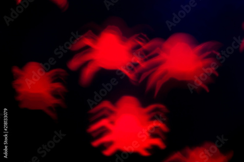 holidays, decoration and party concept - defocused red spiders silhouette on black for halloween background