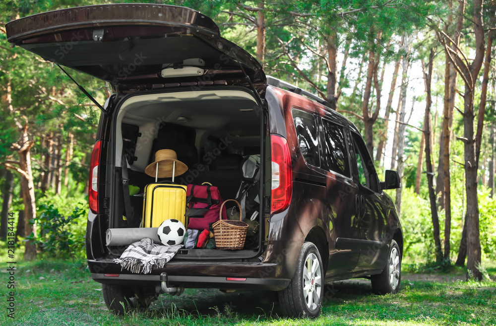 Van with camping equipment in trunk outdoors