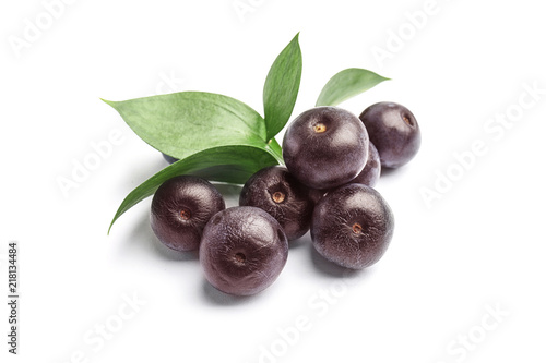 Fresh acai berries with leaves on white background