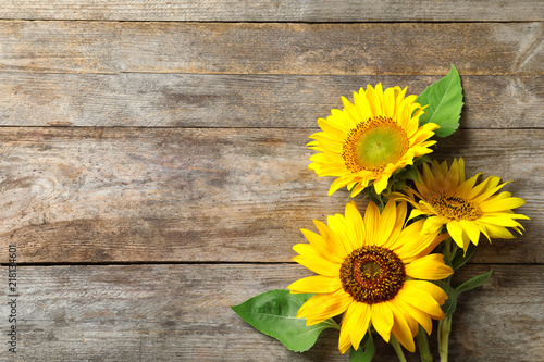 Yellow sunflowers on wooden background, top view