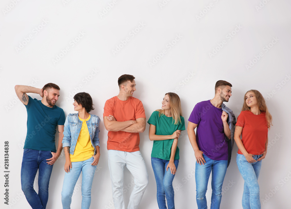 Group of young people in jeans and colorful t-shirts on light background Group of young people in jeans and colorful t-shirts on light background