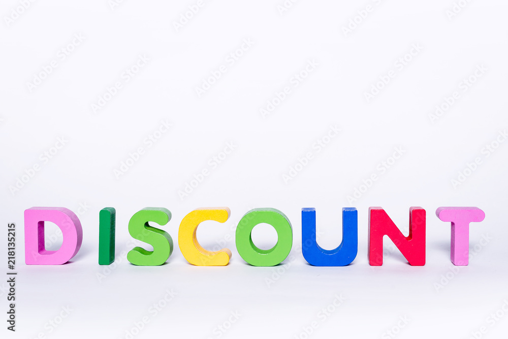 Word DISCOUNT on an isolated white background. DISCOUNT message made up of wooden and colorful letters with scattered letters. Discount concept in the store. Word DISCOUNT on an isolated white background. DISCOUNT message made up of wooden and colorful letters with scattered letters. Discount concept in the store.