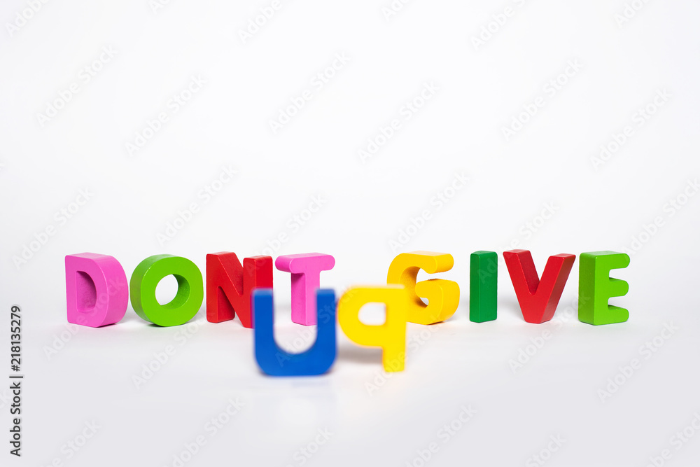 Word DONT GIVE UP. Wooden letters isolated on a white background with the word DONT GIVE UP. The concept of courage and stubbornness in the pursuit of the goal. Word DONT GIVE UP. Wooden letters isolated on a white background with the word DONT GIVE UP. The concept of courage and stubbornness in the pursuit of the goal.
