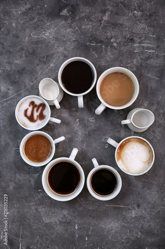 Cups of fresh aromatic coffee on grey background, top view