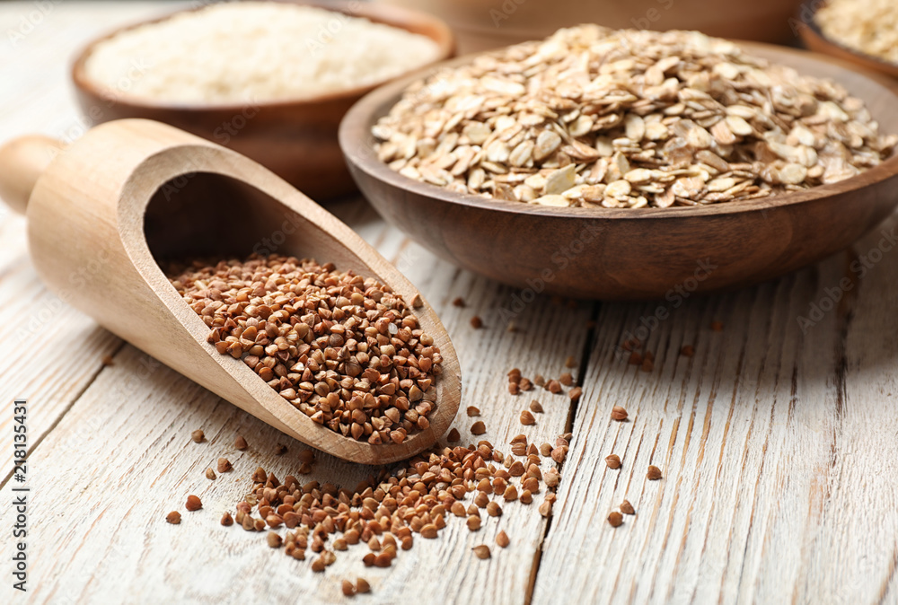 Scoop with buckwheat on wooden table, closeup. Grains and cereals Scoop with buckwheat on wooden table, closeup. Grains and cereals