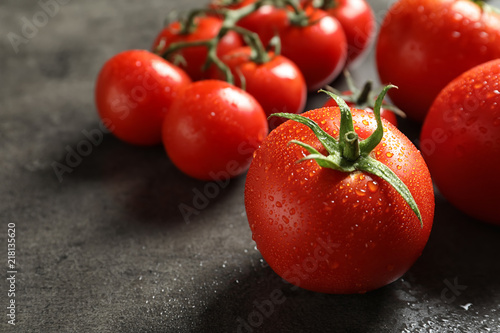 Tasty juicy tomatoes on grey background, closeup
