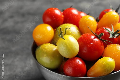 Bowl with tasty juicy tomatoes on table  closeup