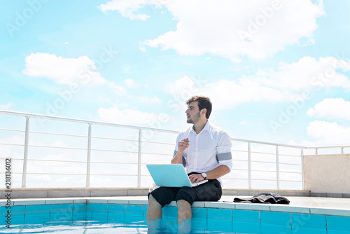 working on laptop at the pool, work on holiday concept