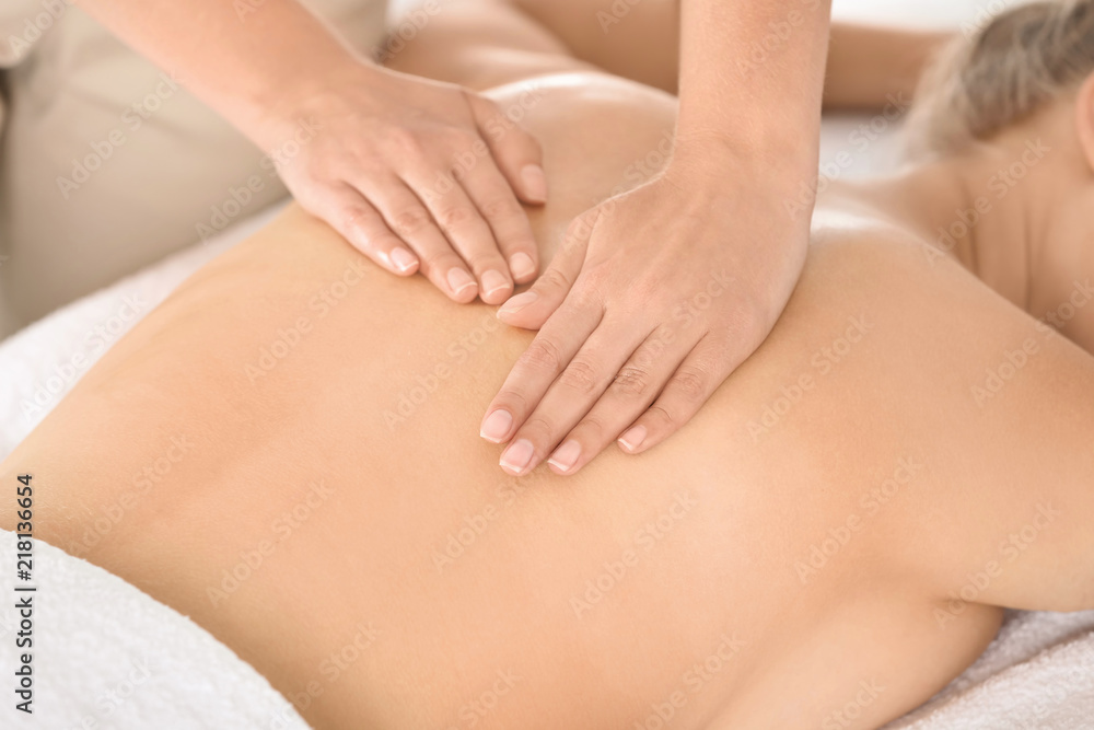 Relaxed woman receiving back massage in wellness center Relaxed woman receiving back massage in wellness center
