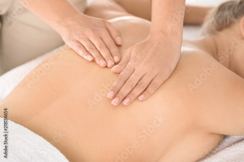 Relaxed woman receiving back massage in wellness center © New Africa