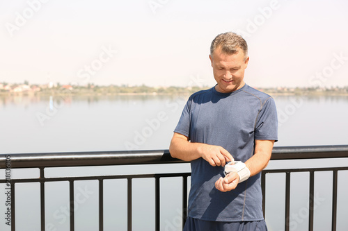 Man checking pulse outdoors on sunny day