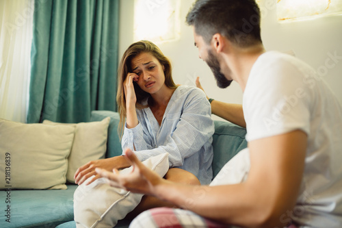 Young couple is arguing at home, man is shouting at his crying wife