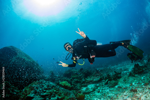 A SCUBA diver exploring a dark tropical coral reef