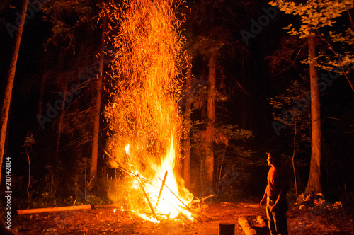 Image of a large campfire, around which people basking at night © SoWin