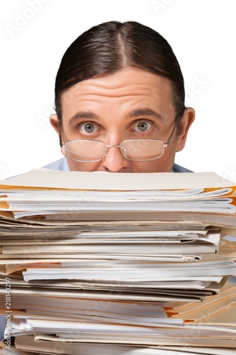 Closeup of an Employee Behind a Stack of Documents