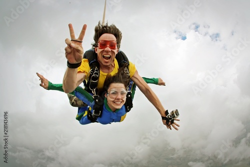 Obraz na plátně Skydiving tandem happiness on a cloudy day