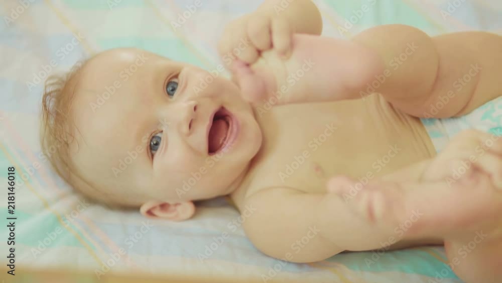 beautiful newborn lying on back looking into camera and smiling. beautiful newborn lying on back looking into camera and smiling.